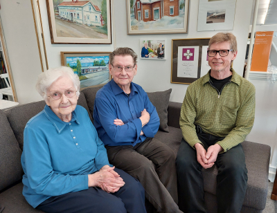 Sisko, Veijo ja Jyrki Viitala asettuivat kuvaan liikkeessä olevan tauluseinän ääreen, jossa kerrotaan heidän 60-vuotisen yrityksensä tarinaa.